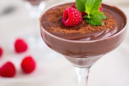 Decadent Vegan Chocolate Avocado Mousse 11 Decadent vegan chocolate avocado mousse in glass dishes garnished with raspberries and cocoa powder.