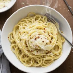 a white bowl of simple garlic butter spaghetti with parmesan