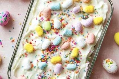 Irresistible Creamy Easter Poke Cake with Hidden Candy Layers 14 an easter poke cake in the tray decorated with pastel eggs