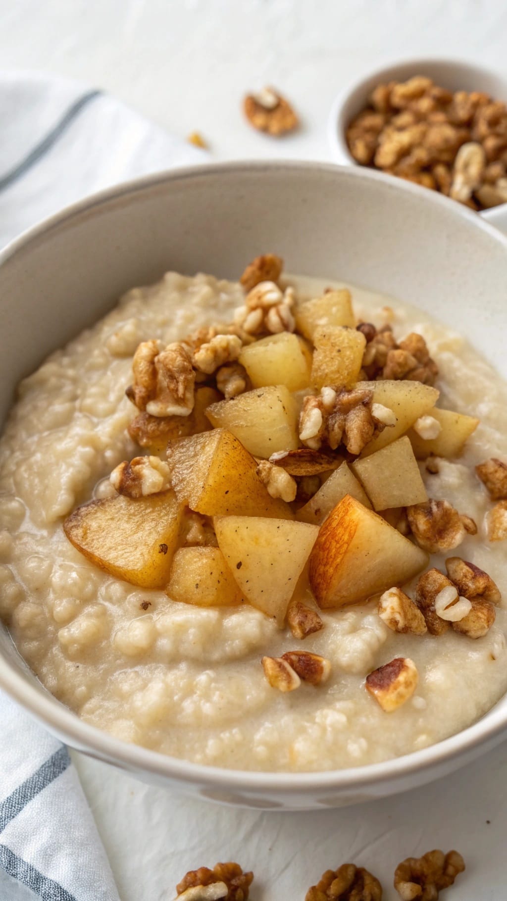 25 Delicious Christmas Breakfast Ideas for a Festive Morning 22 A bowl of spiced pear and walnut porridge topped with diced pears and walnuts.